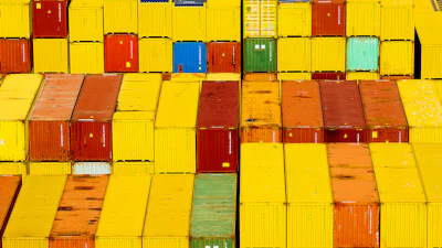 Stacked shipping containers in vibrant yellow, red, and orange colors