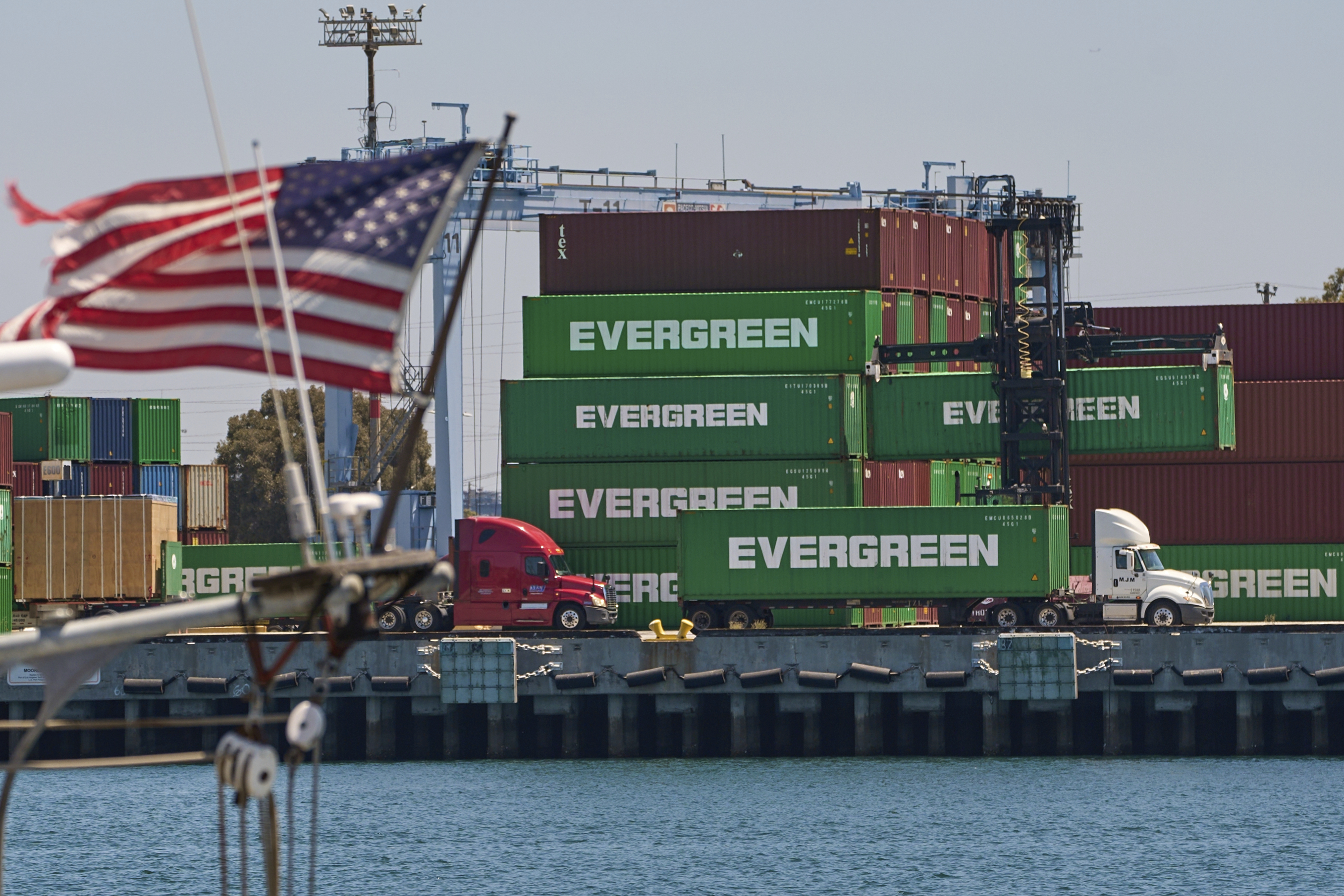 Green Evergreen shipping containers stacked at port with American flag waving