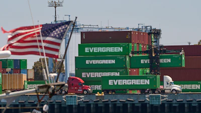 Green Evergreen shipping containers stacked at port with American flag waving