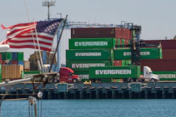 Green Evergreen shipping containers stacked at port with American flag waving