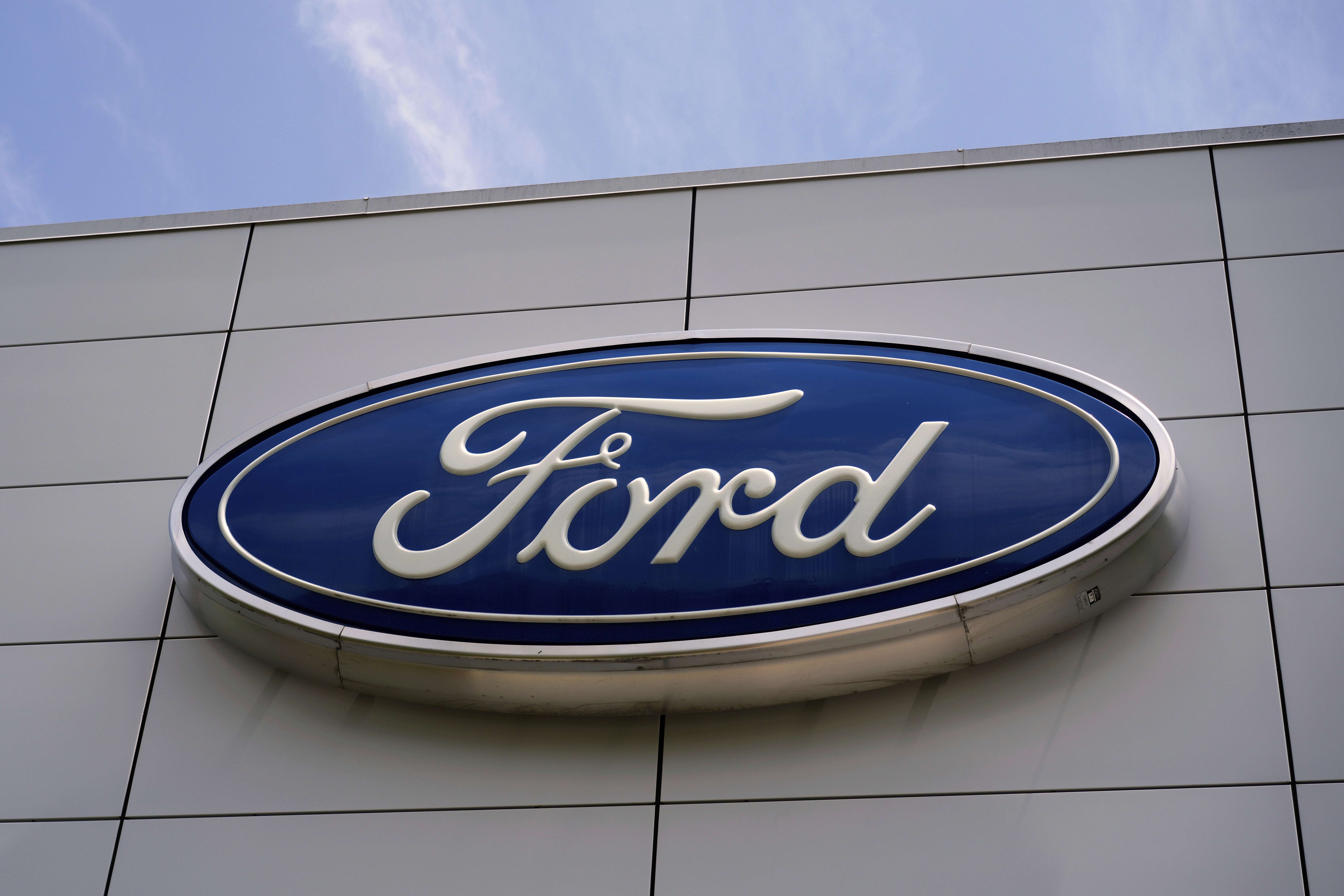 Ford automotive logo in blue and white on modern building exterior