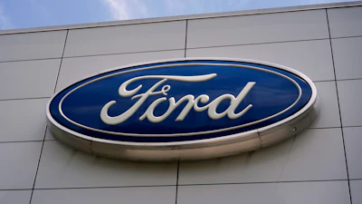 Ford automotive logo in blue and white on modern building exterior
