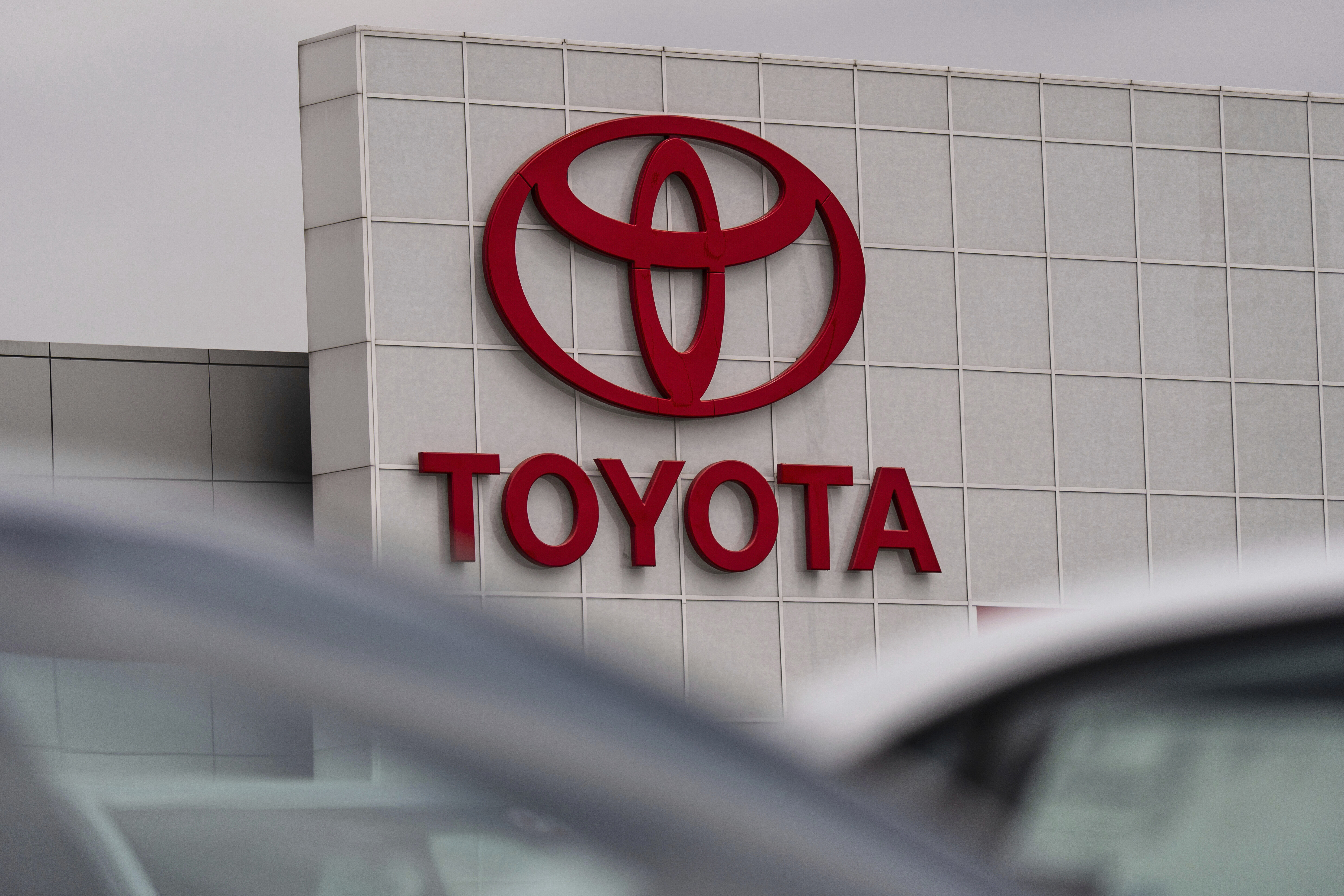 Toyota corporate logo in bold red letters and oval symbol on white building exterior
