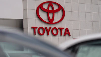 Toyota corporate logo in bold red letters and oval symbol on white building exterior