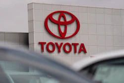 Toyota corporate logo in bold red letters and oval symbol on white building exterior