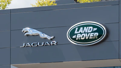 Jaguar Land Rover corporate headquarters with brand logos on modern gray building