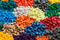 Colorful polymer pellets in blue, red, green, yellow, orange, and gray arranged in clusters