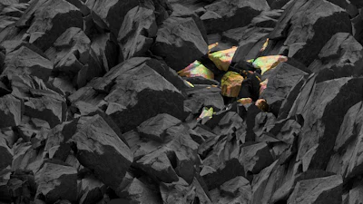 Dark rocky landscape with scattered iridescent crystal formations emerging from black stone formations