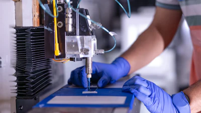 Precision robotic machine with blue-gloved hands performing scientific or manufacturing process