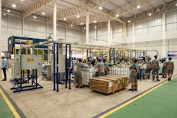 Industrial facility with workers operating machinery and equipment on green floor