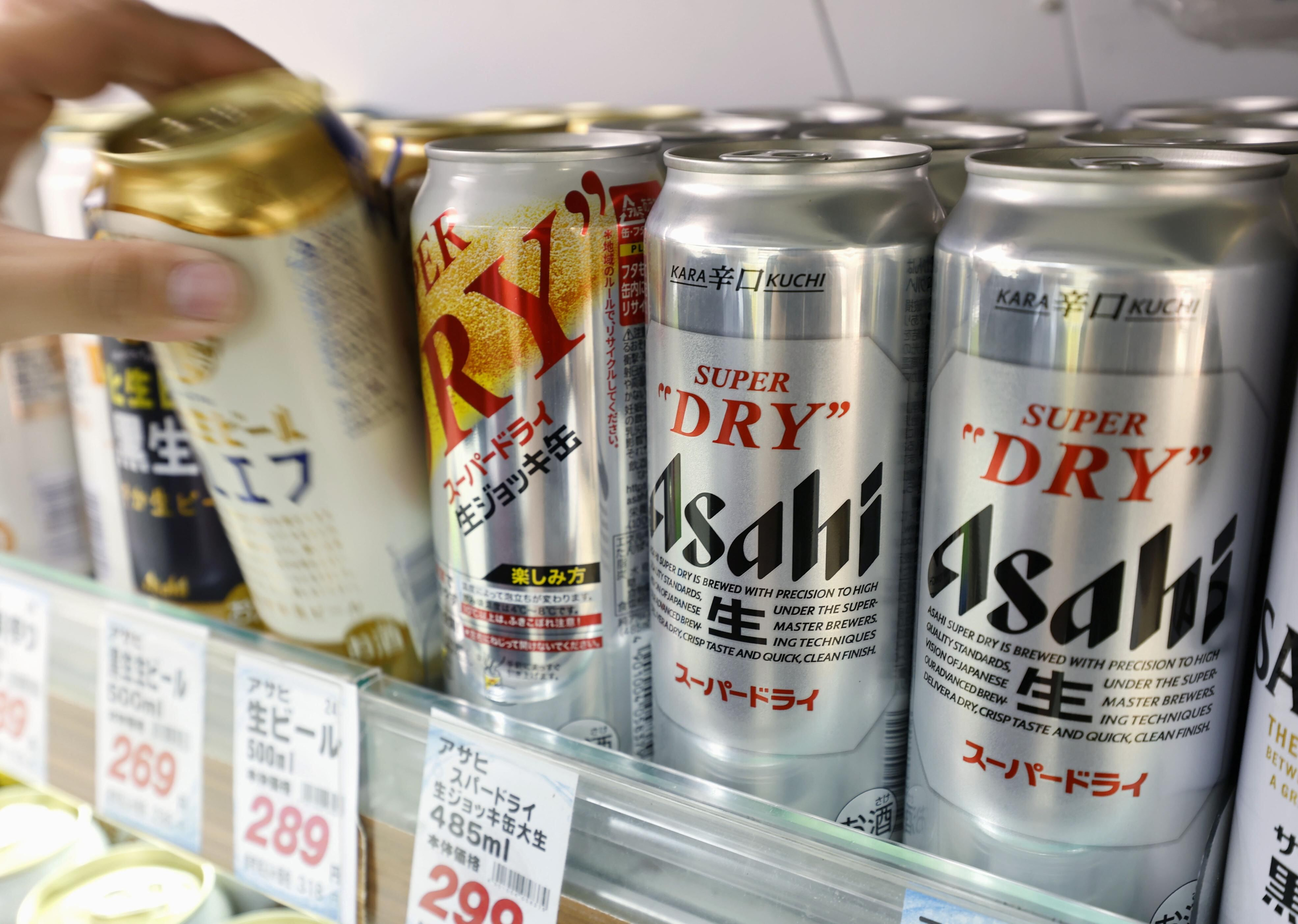 Silver Asahi Super Dry beer cans displayed on store shelf with price tags