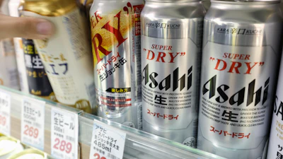 Silver Asahi Super Dry beer cans displayed on store shelf with price tags
