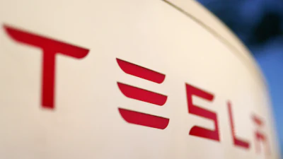 Tesla logo in bold red letters on a light background