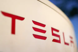 Tesla logo in bold red letters on a light background