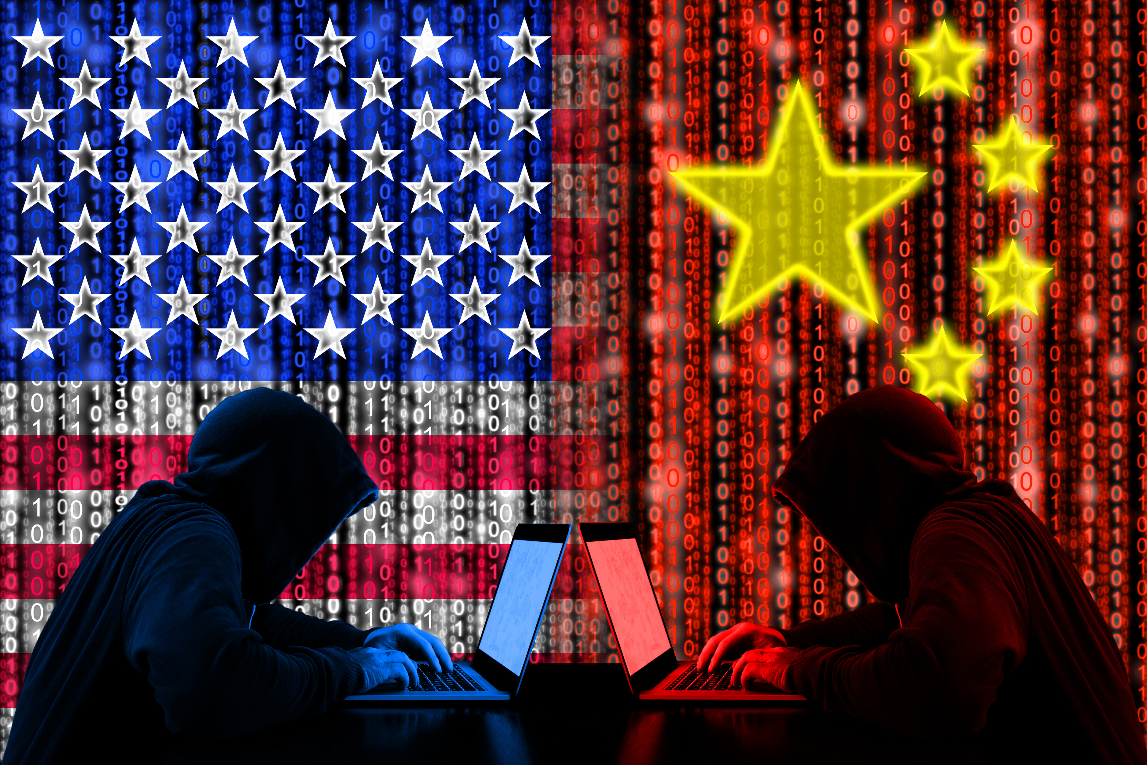 Hooded hackers with laptops against US and China flags with binary code backdrop