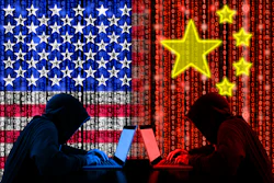 Hooded hackers with laptops against US and China flags with binary code backdrop