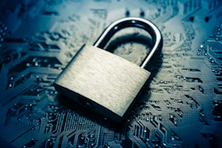 Metallic padlock resting on blue circuit board, symbolizing digital security
