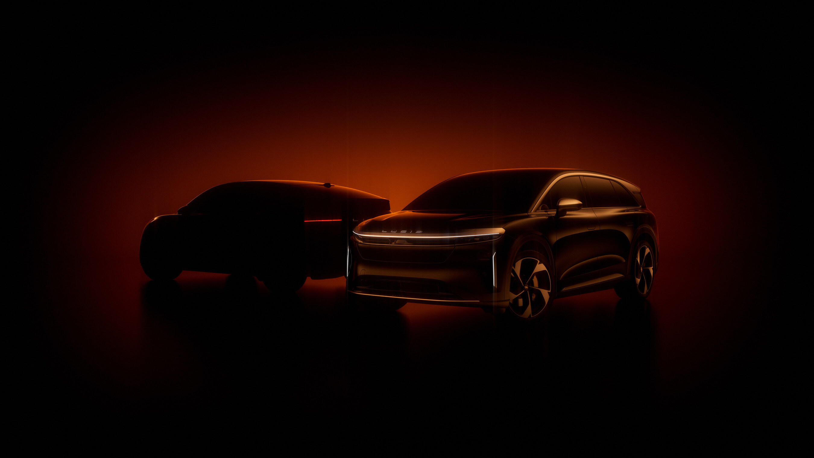 Two sleek electric SUVs silhouetted against a dramatic red-orange background