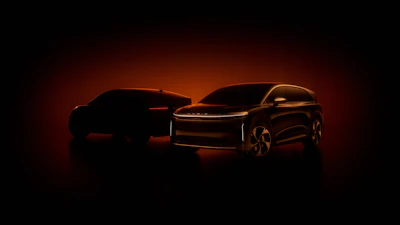 Two sleek electric SUVs silhouetted against a dramatic red-orange background