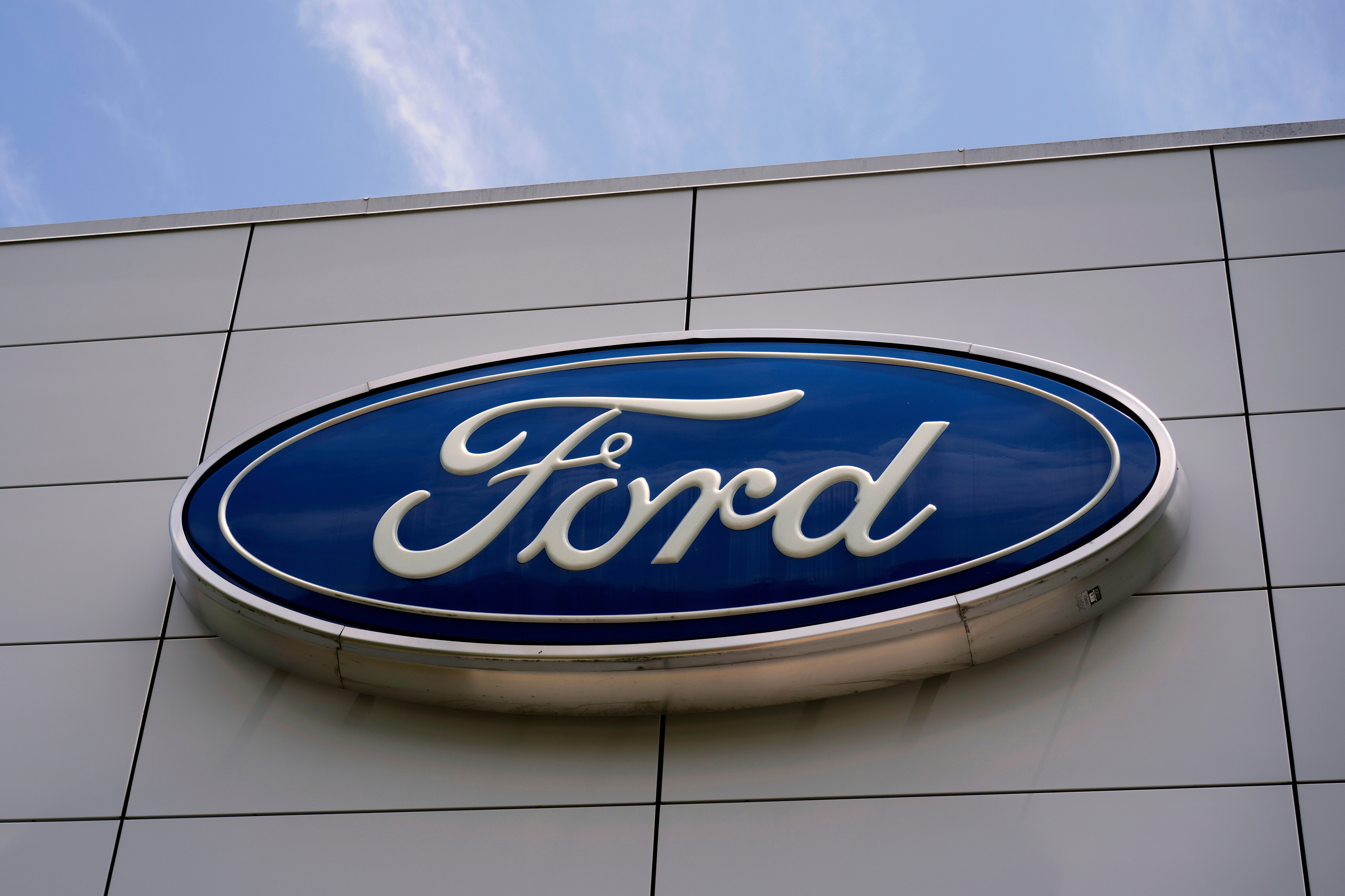 Ford automotive logo in blue and white on modern building exterior