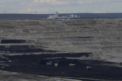 Expansive open-pit coal mine with layered terrain and mining vehicles