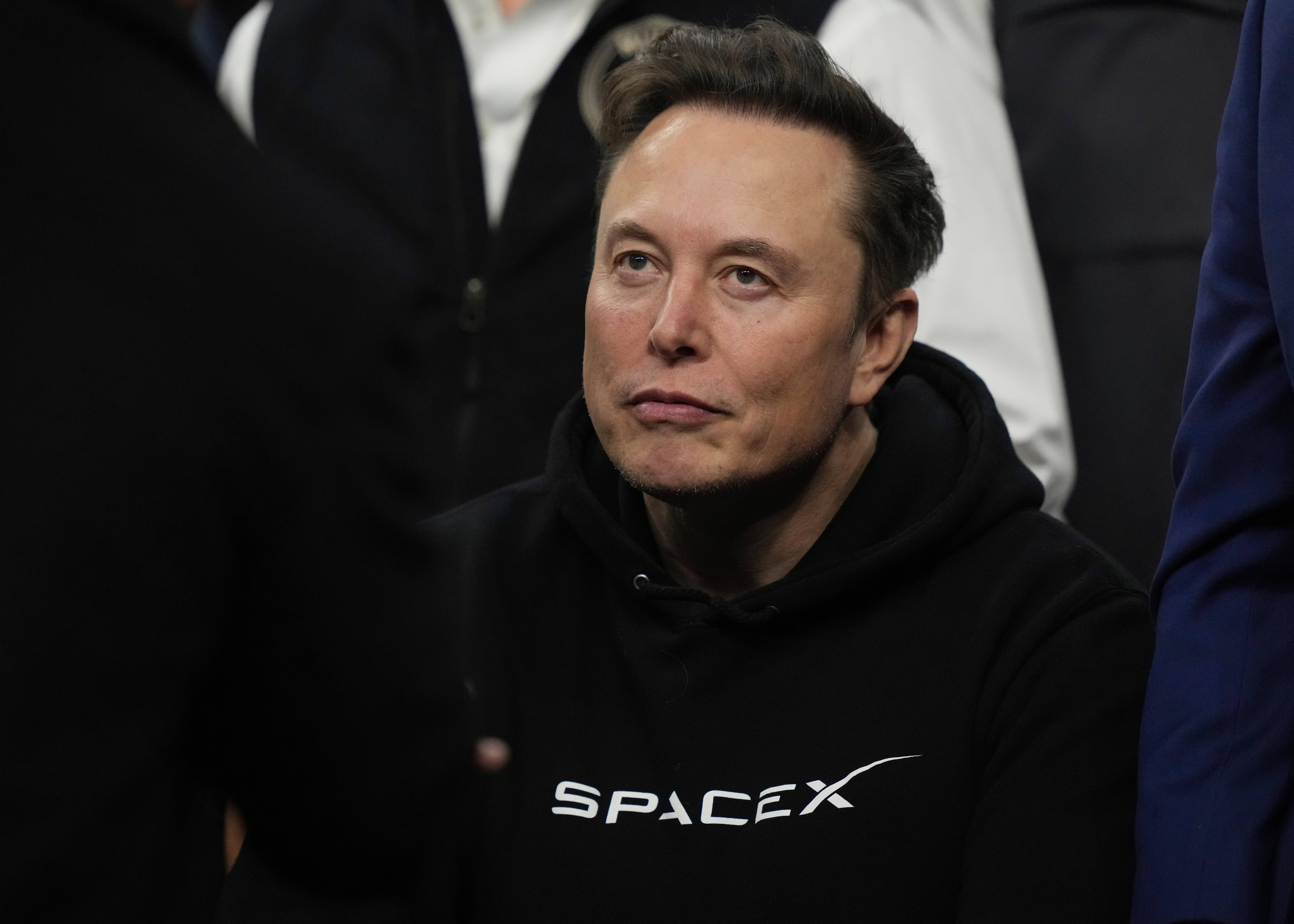Person wearing black SpaceX hoodie looking off-camera