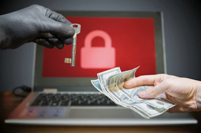 Cybersecurity threat: Gloved hand holding key over cash, laptop with lock icon