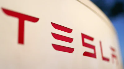 Tesla logo in bold red letters against a light background