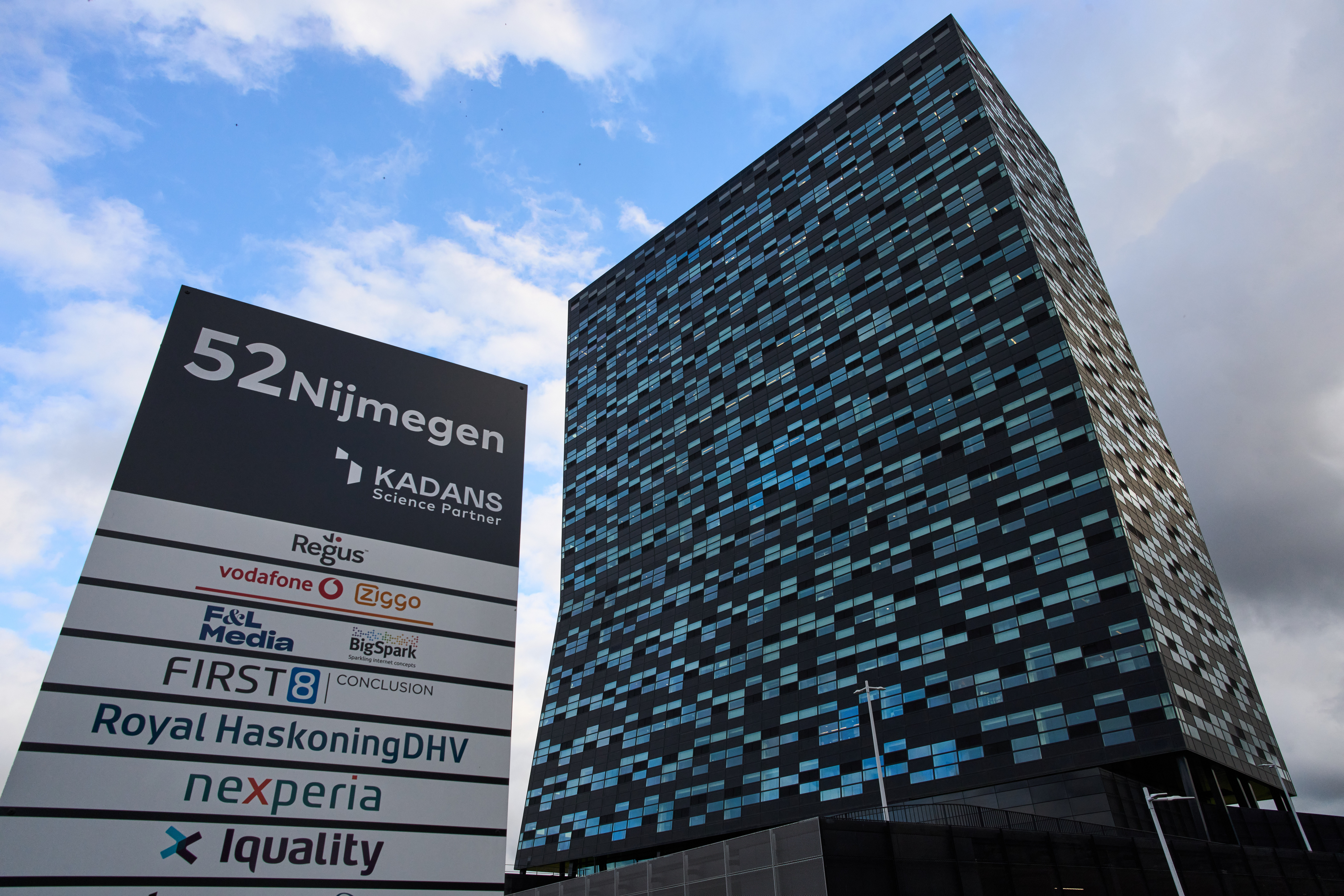 Modern blue-gray office building with corporate sign at 52 Nijmegen complex