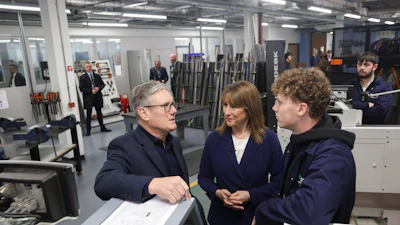 Business professionals discussing project in industrial workshop with machinery