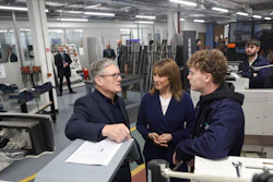 Business professionals discussing project in industrial workshop with machinery