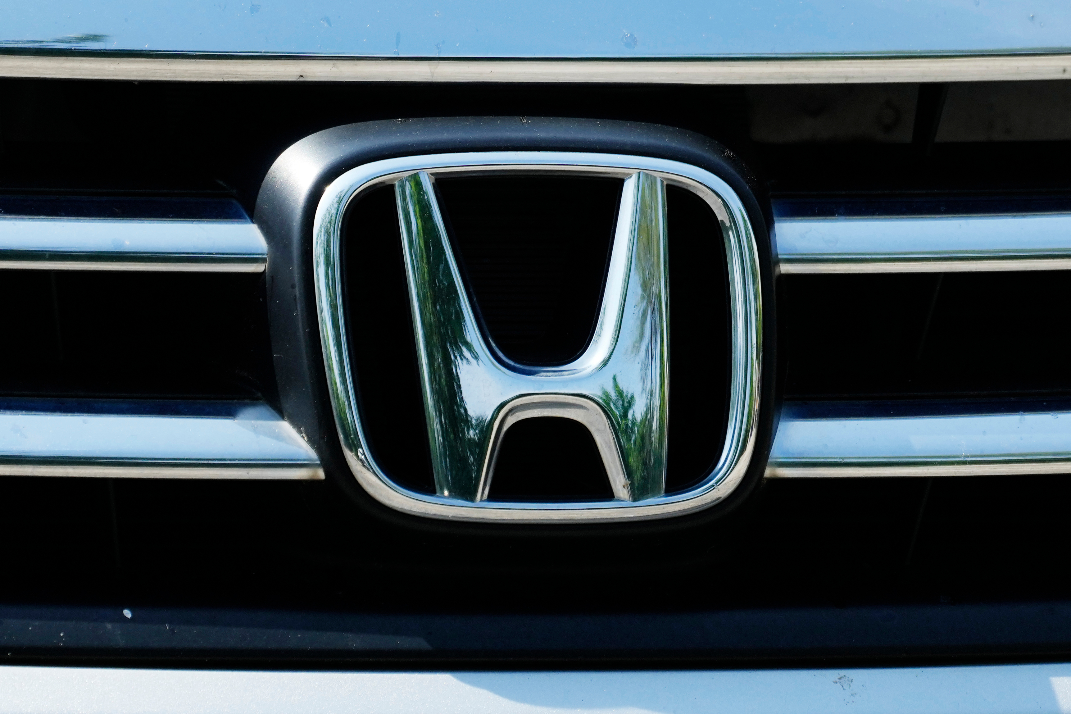 Honda automotive logo on vehicle grille with chrome metallic finish