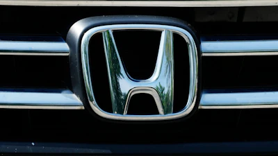 Honda automotive logo on vehicle grille with chrome metallic finish