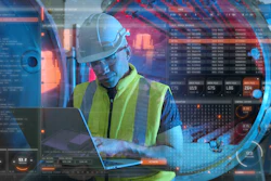 Industrial worker in safety vest analyzing data on laptop with futuristic digital interface