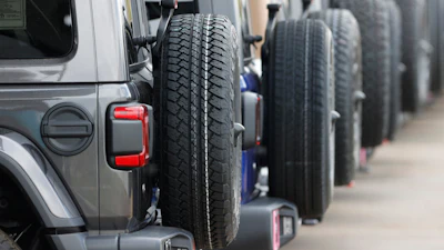 Row of spare tires mounted on the sides of gray SUVs or off-road vehicles