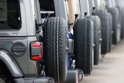Row of spare tires mounted on the sides of gray SUVs or off-road vehicles