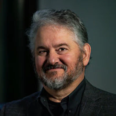 Smiling middle-aged man with gray beard wearing black shirt