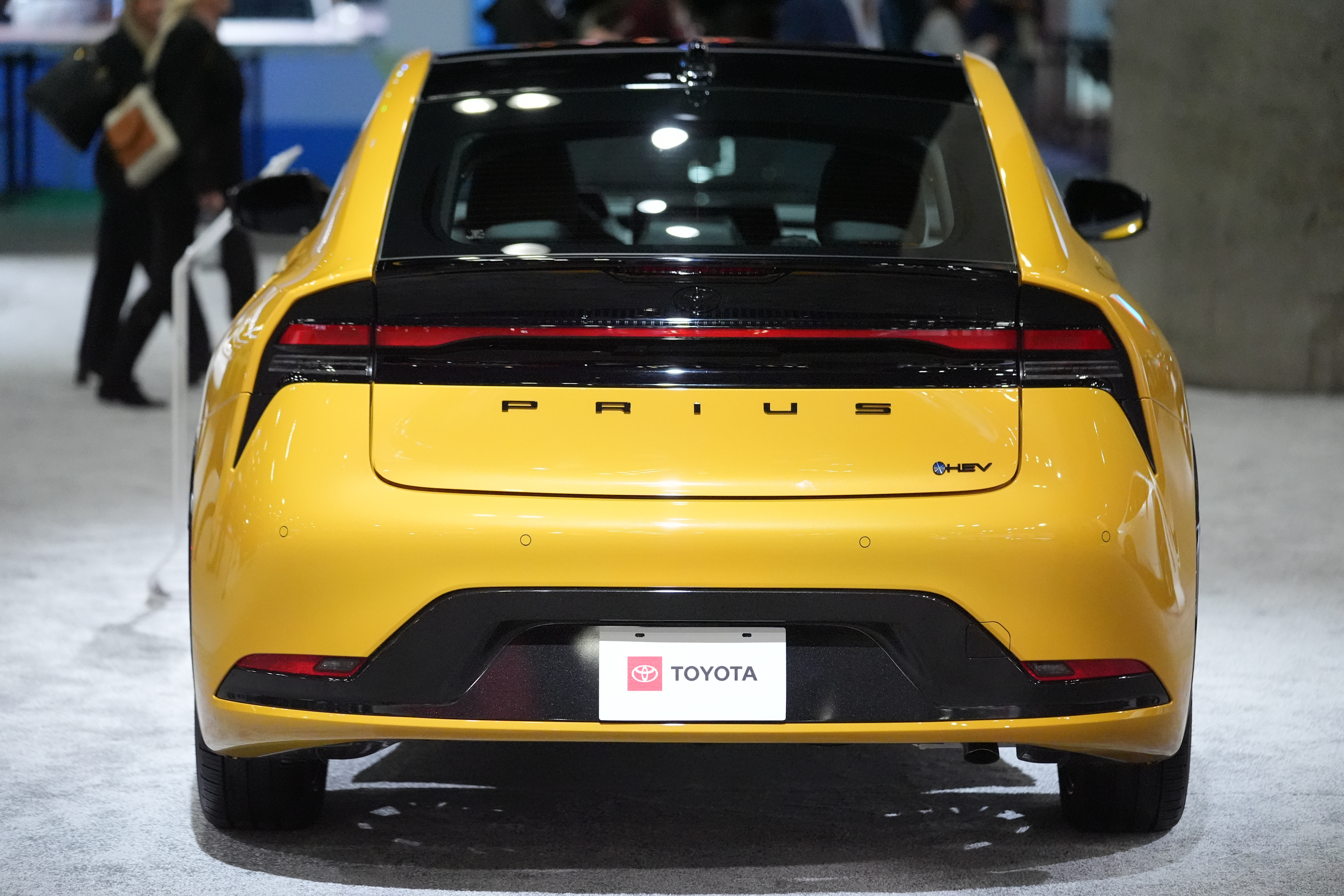 Yellow Toyota Prius hybrid car displayed at automotive show