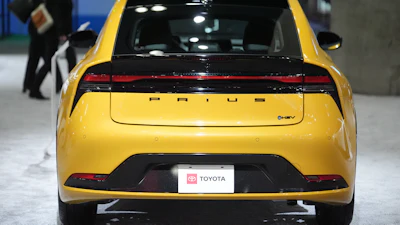 Yellow Toyota Prius hybrid car displayed at automotive show