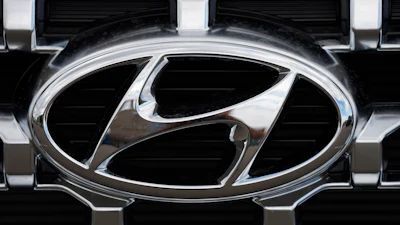 Hyundai chrome logo on vehicle grille with metallic silver and black details