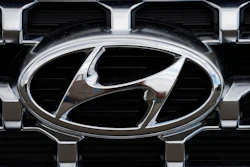 Hyundai chrome logo on vehicle grille with metallic silver and black details