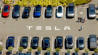 Aerial view of Tesla parking lot with multiple electric vehicles in different colors