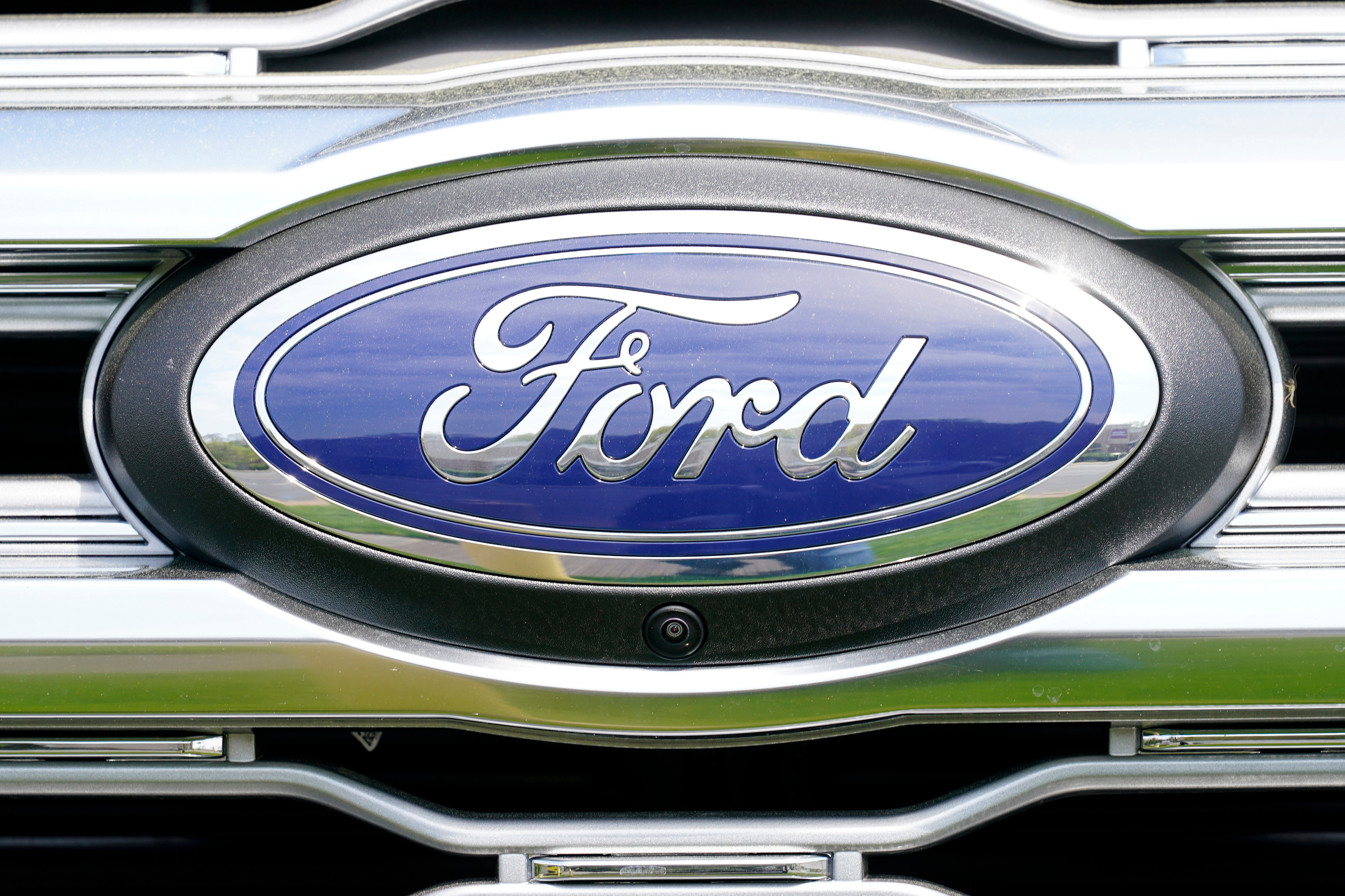 Ford automotive logo emblem on vehicle grille with blue and chrome design