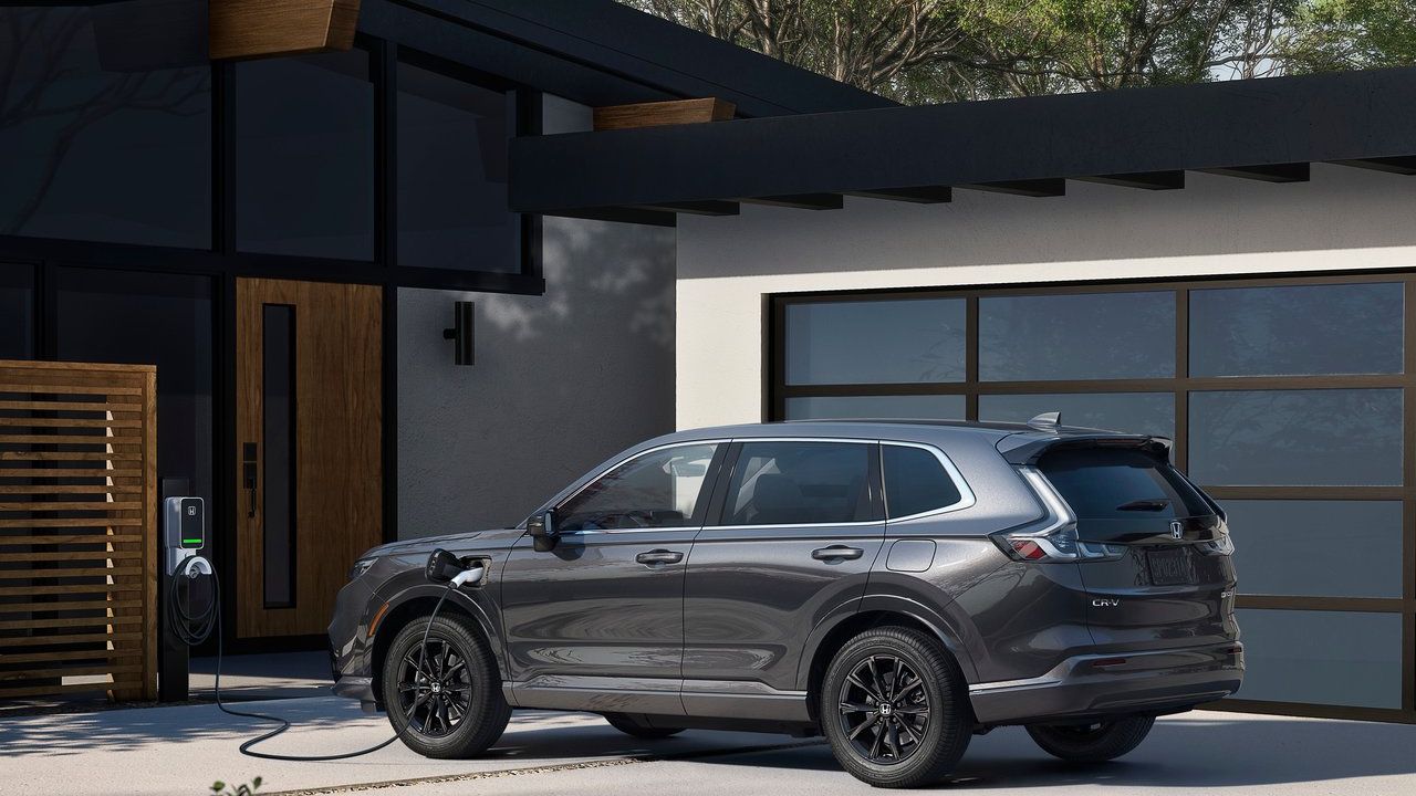 Gray Honda SUV charging at a modern home with glass garage door