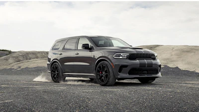 Black Dodge Durango SUV parked on rocky terrain with dusty background