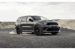Black Dodge Durango SUV parked on rocky terrain with dusty background