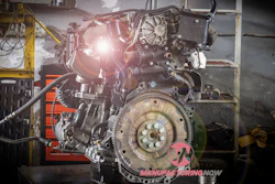 Exposed automotive engine with complex mechanical parts in industrial workshop
