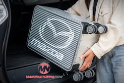 Industrial device with Manufacturing Now logo being placed in vehicle trunk