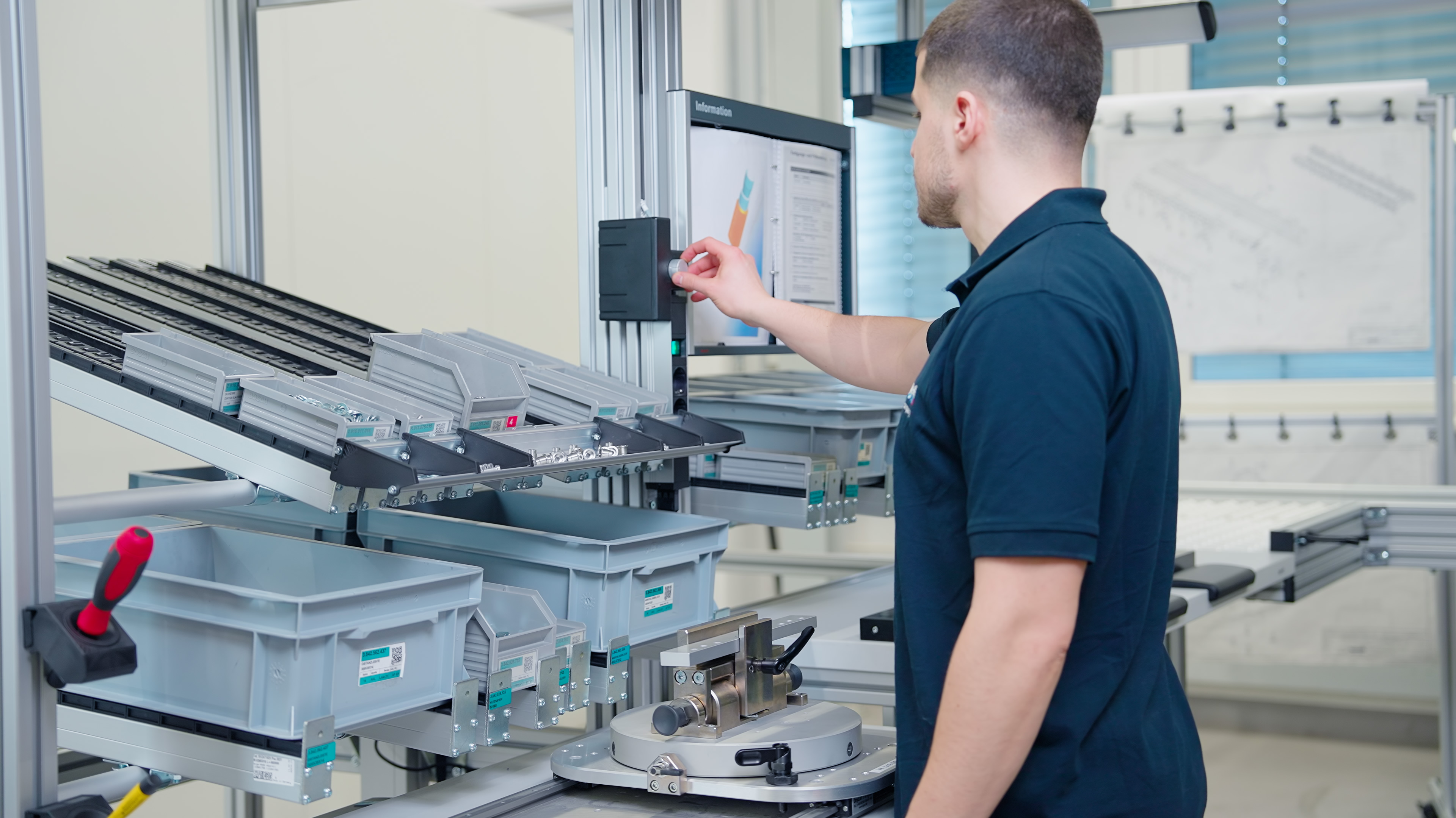 Technician operating industrial sorting and assembly machine in manufacturing facility