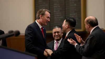 Government officials in suits shaking hands during formal meeting